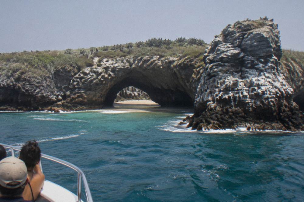 Blue water and rock formations at the Marietas Islands seen from a boat deck