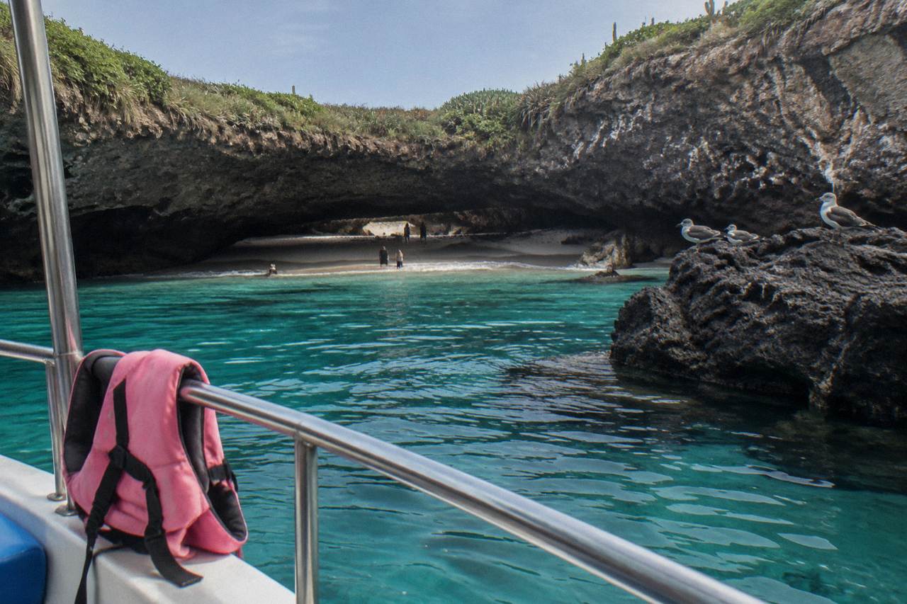Cal turquoise water and rocky crater walls at a sheltered island beach
