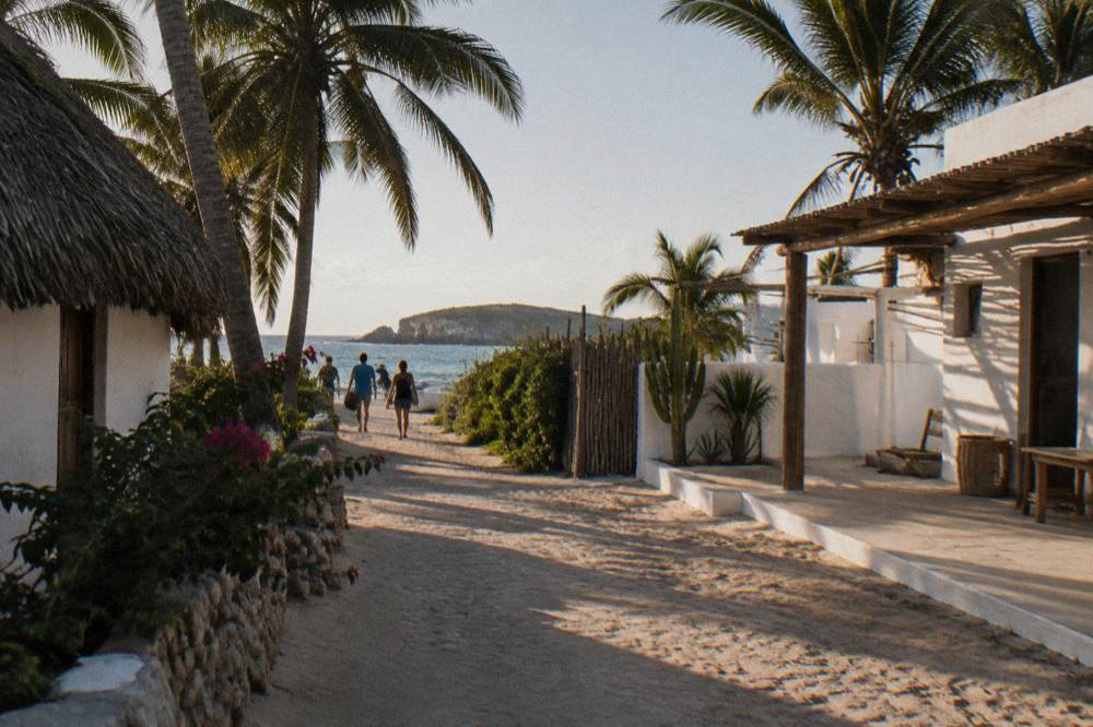 A quiet beach street with palms and low buildings in late afternoon light
